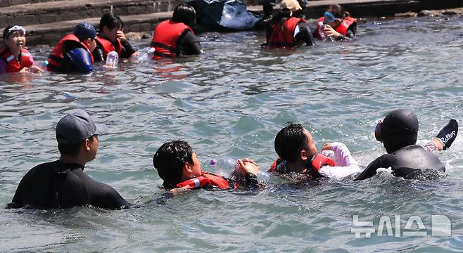 [서귀포=뉴시스] 우장호 기자 = 8일 오전 제주 서귀포시 법환 해녀체험장에서 제주도교육청과 해녀·해군기동함대사령부가 협동해 강정초등학교 학생들에게 '제주형 생존수영' 교육을 하고 있다. 이번 생존수영 교육은 법환 어촌계 해녀, 해군 해난구조대(SSU)가 함께하는 전국 최초의 프로그램으로 서귀포시 관내 초등학교 5~6학년 학생 100여명(3개교)을 대상으로 8월15일까지 운영된다. 2025.07.08. woo1223@newsis.com