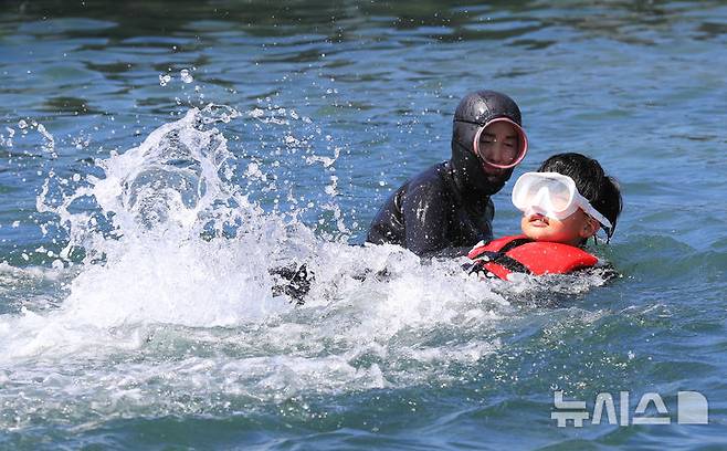 [서귀포=뉴시스] 우장호 기자 = 8일 오전 제주 서귀포시 법환 해녀체험장에서 제주도교육청과 해녀·해군기동함대사령부가 협동해 강정초등학교 학생들에게 '제주형 생존수영' 교육을 하고 있다. 이번 생존수영 교육은 법환 어촌계 해녀, 해군 해난구조대(SSU)가 함께하는 전국 최초의 프로그램으로 서귀포시 관내 초등학교 5~6학년 학생 100여명(3개교)을 대상으로 8월15일까지 운영된다. 2025.07.08. woo1223@newsis.com