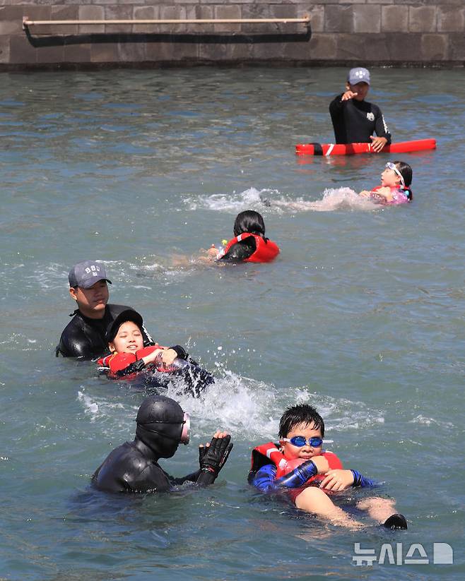 [서귀포=뉴시스] 우장호 기자 = 8일 오전 제주 서귀포시 법환 해녀체험장에서 제주도교육청과 해녀·해군기동함대사령부가 협동해 강정초등학교 학생들에게 '제주형 생존수영' 교육을 하고 있다. 이번 생존수영 교육은 법환 어촌계 해녀, 해군 해난구조대(SSU)가 함께하는 전국 최초의 프로그램으로 서귀포시 관내 초등학교 5~6학년 학생 100여명(3개교)을 대상으로 8월15일까지 운영된다. 2025.07.08. woo1223@newsis.com