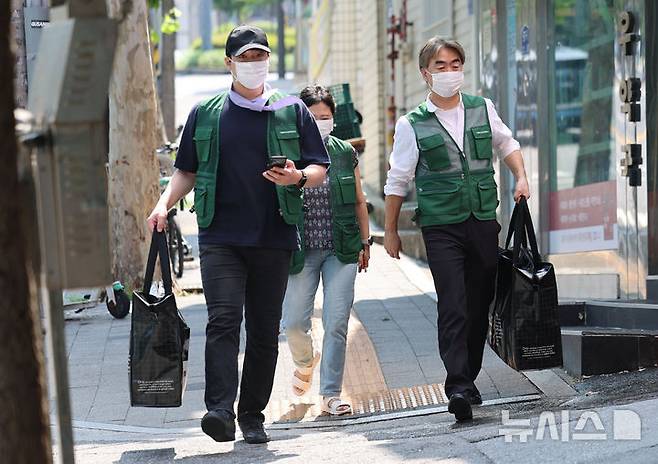 [서울=뉴시스] 권창회 기자 = 염영남 뉴시스 대표이사를 비롯한 직원들이 8일 서울 용산구 쪽방촌에서 도시락 배달 봉사를 하기 위해 이동하고 있다. 2025.07.08. kch0523@newsis.com