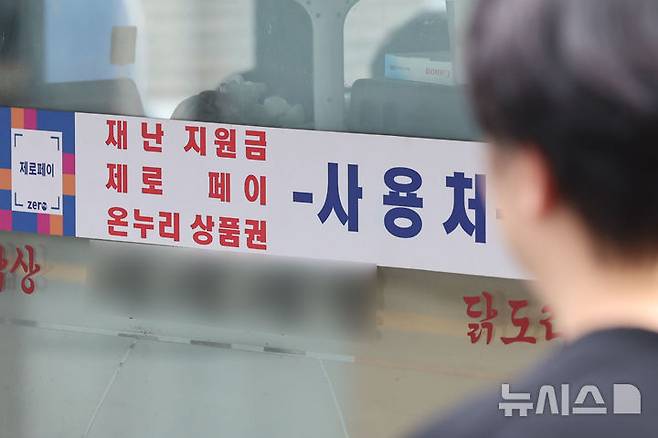 [서울=뉴시스] 권창회 기자 = 경기 부양을 위한 이재명 정부의 첫 민생회복 소비쿠폰이 오는 21일부터 지급된다. 1차로 우선 15만~45만원을 지급하며, 9월 22일부터 소득 상위 10%를 제외한 국민 90%에게 10만원을 추가 지급할 예정이다. 난민 인정자도 받을 수 있으며 대형마트, 명품관, 배달앱 등에서의 사용은 제한된다. 사진은 7일 서울 시내 전통시장 내 지역화폐 결제 가능 매장의 모습. 2025.07.07. kch0523@newsis.com