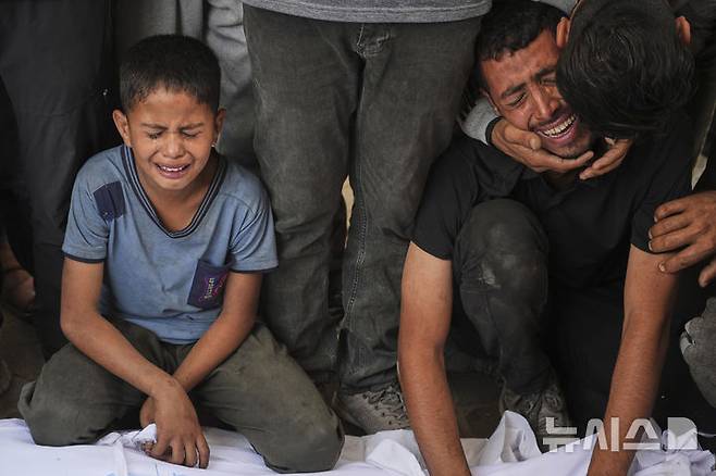 [가자시티=AP/뉴시스] 지난달 28일(현지 시간) 가자지구 가자시티 알시파 병원에서 팔레스타인 주민들이 이스라엘의 공습으로 숨진 가족의 시신 앞에 주저앉아 오열하고 있다. 2025.06.29.