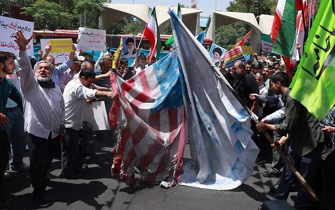 6월20일 이란 테헤란에서 열린 시위에서 이란 시민들이 미국과 이스라엘 국기를 태우고 있다. ⓒEPA