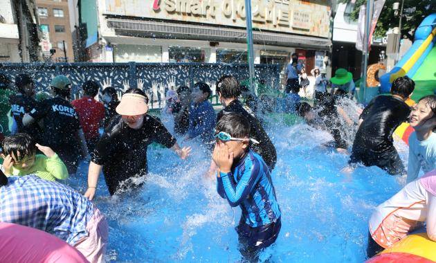 광주시 동구가 오는 8월 2일 차없는 거리 행사에서 금남로 일대에 워터슬라이드와 풀장을 설치한다. 사진은 지난 5일 열린 행사에서 시민들이 풀장을 이용하는 모습. <광주시 동구 제공>
