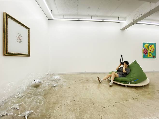 홍희령 작가가 자신의 작품 '여기가 지상낙원'을 감상하는 방법을 선보이고 있다.<아트스페이스펄 제공>