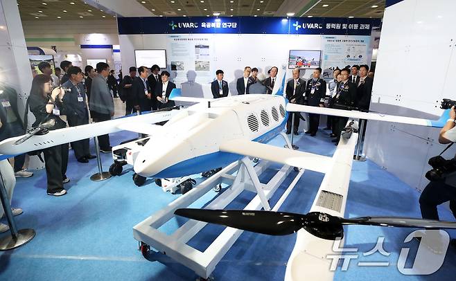 17일 서울 강남구 코엑스에서 막을 올린 ‘2024 무인이동체산업엑스포’(2024 UWC)에서 내빈과 관람객들이 한국항공우주연구원 부스에서 육공 분리합체형 배송용 무인이동체를 살펴보고 있다. 2024.7.17/뉴스1 ⓒ News1 오대일 기자