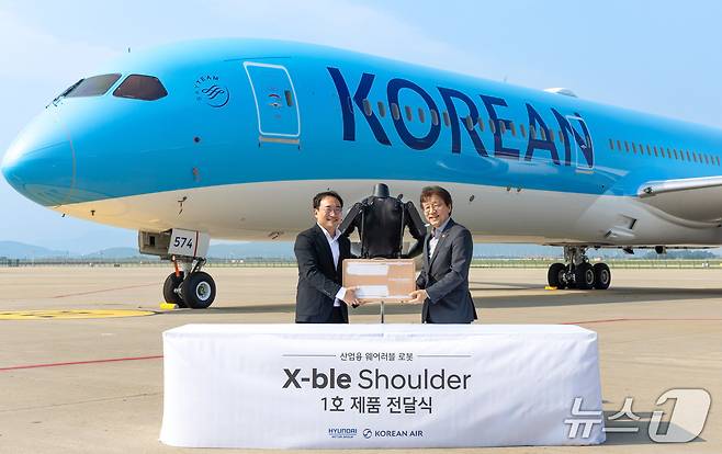 8일 인천 중구 소재 대한항공 항공기 정비고에서 현대자동차·기아가 개발한 산업용 착용로봇 '엑스블 숄더'(X-ble Shoulder) 1호 인도식이 열렸다. (왼쪽부터) 현동진 현대차·기아 로보틱스랩 상무, 정현보 대한항공 항공우주사업본부 상무가 기념 사진을 촬영한 모습(현대차·기아 제공). 2025.07.08.