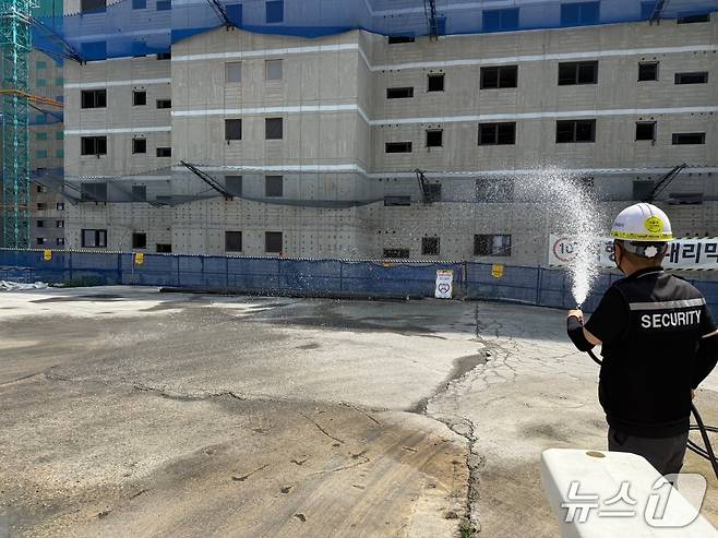 경기도 전역에 폭염경보가 발령된 9일 오후 수원시 팔달구 소재 아파트 건설 현장에서 작업자가 바닥에 물을 뿌리고 있다. 2025.7.9/뉴스1 ⓒ News1 김기현 기자