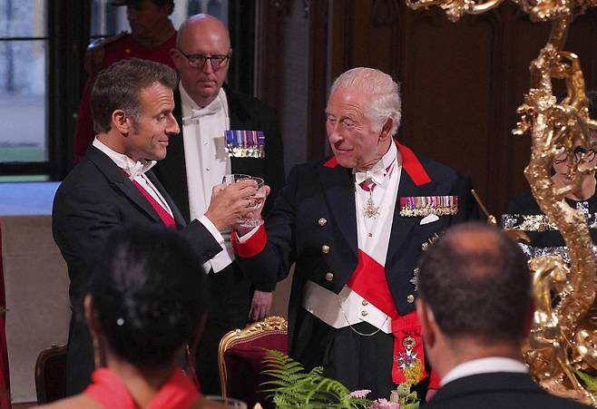 찰스 3세(오른쪽) 영국 국왕과 에마뉘엘 마크롱 프랑스 대통령이 8일(현지 시간) 영국 윈저성에서 열린 국빈 만찬 중 건배하고 있다. 마크롱 대통령이 찰스 3세 국왕의 초청으로 브렉시트 이후 처음으로 영국을 국빈 방문했다. 그는 영국과 프랑스가 이 위험한 세계에서 민주주의와 법치, 국제 질서를 수호하며 “유럽을 구할 것”이라고 말했다. 2025.07.09. [윈저=AP/뉴시스]