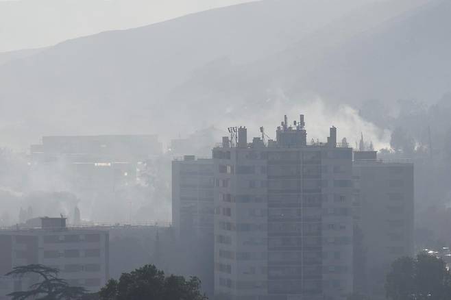 8일(현지 시간) 프랑스 남부 마르세유의 라 카스텔란 지역에서 산불이 발생해 건물 뒤편으로 연기가 피어오르고 있다. 산불이 확산하면서 마르세유 공항과 철도 운행이 중단됐으며 프랑스 기상청은 인근 지역에 적색경보를 발령했다. 2025.07.09. [마르세유=AP/뉴시스]
