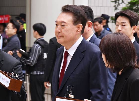 윤석열 전 대통령이 국민의힘 탈당 이틀 후인 지난 5월 19일 오전 서울 서초구 중앙지방법원에서 열린 내란 우두머리 혐의, 직권남용 권리행사방해 혐의 사건 4차 공판에 출석, 취재진의 질문을 받으며 이동하고 있다. 사진공동취재단