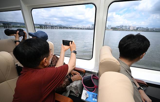 People take photos of the view from the Hangang Bus during the inaugural public ride on July 1. [JOINT PRESS CORPS]