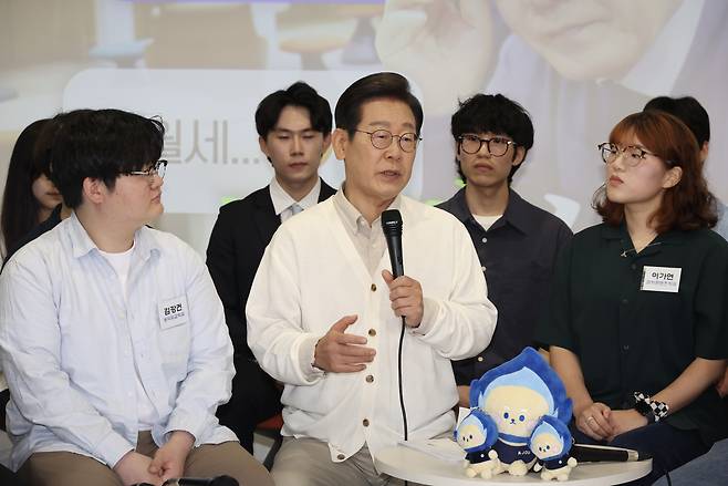 Democratic Party candidate Lee Jae-myung, center, speaks to students at Ajou University in Suwon, Gyeonggi, on May 26. [JOINT PRESS CORPS]