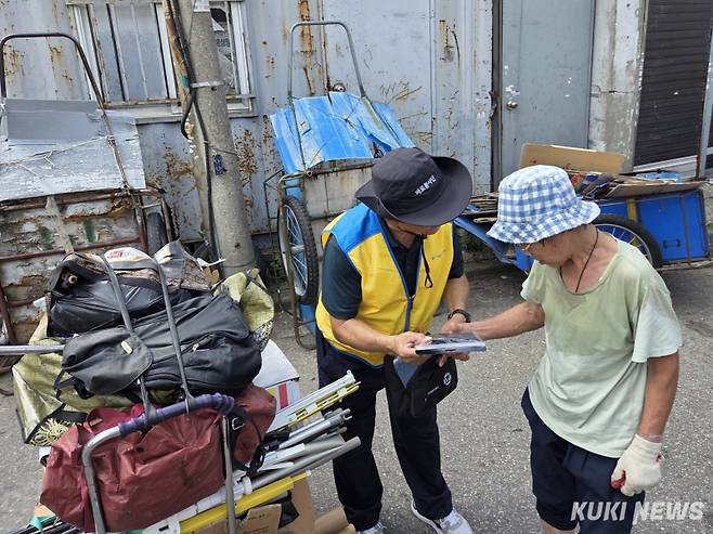 8일 오후 3시30분 서울 성동구 한 폐지 수집 업체 앞에서 폐지 줍는 어르신이 자원봉사자로부터 쿨키트를 건네받고 있다. 노유지 기자