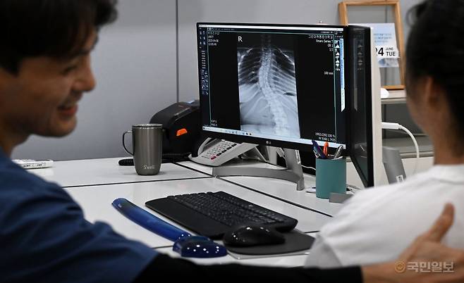 희소질환인 ‘루빈스타인-테이비 증후군’을 앓고 있는 박하진양의 척추는 37도나 휘었다. 지난달 24일 의료진이 엑스레이 사진을 보며 진료를 하고 있다. 부평그린마취통증의학과의원은 박양의 진료비와 재활 치료비 전액을 지원하고 있다.