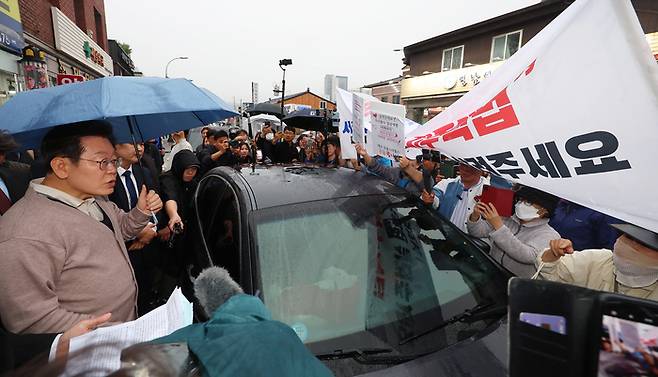 이재명 대통령(당시 더불어민주당 대선 후보)가 제3차 골목골목 경청투어로 경북지역 방문에 나선 지난 5월 9일 경북 고령군에서 대구에서 온 시민들의 지역주택조합 관련 하소연을 경청하고 있다. 사진과 기사는 관련 없음. [사진 = 연합뉴스]