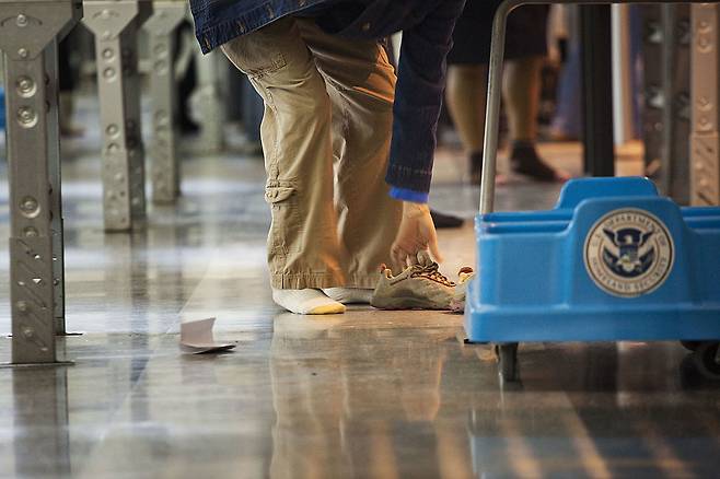미국 뉴욕시 존 F. 케네디 국제공항에서 한 승객이 보안 검색대를 통과하기 전 신발을 벗고 있다. [게티이미지]
