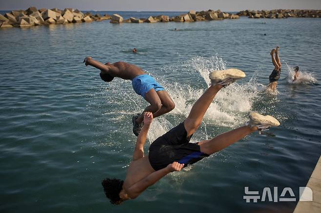 [바르셀로나=AP/뉴시스]스페인에 무더위가 이어진 1일 바르셀로나 해변에서 남성들이 물로 뛰어들고 있다. 지난달 말 서유럽을 강타한 파괴적 폭염으로 12개 주요 도시에서 약 2300명의 사망자를 낸 것으로 추정된다고 9일 발표된 과학적 분석 결과에서 나타났다고 아제르바이잔의 뉴스닷에이제트(news.az)가 보도했다. 2025.07.09.