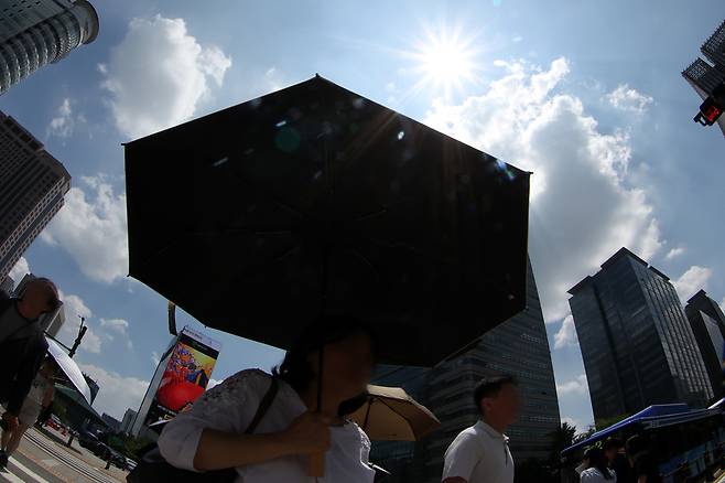 전국 대부분 지역에 폭염경보가 발효된 9일 서울 시내에서 시민이 양산을 쓰고 이동하고 있다. 뉴시스