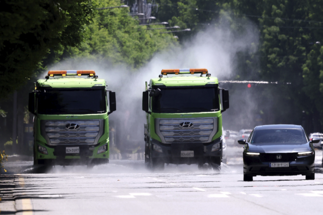 30도가 넘는 무더운 날씨가 이어지고 있는 가운데 광주광역시 북구청 직원들이 살수차를 이용해 도로에 물을 뿌리고 있다. 뉴스1