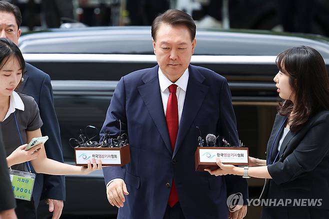 출석하는 윤석열 전 대통령 (서울=연합뉴스) 12·3 비상계엄과 관련해 특검의 수사를 받는 윤석열 전 대통령이 9일 서울 서초구 서울중앙지법에서 열린 영장실질심사에 취재진의 질문을 받으며 출석하고 있다. 2025.7.9 [사진공동취재단] photo@yna.co.kr