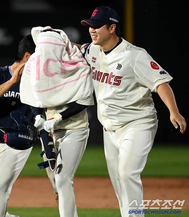 끝내기 안타로 승리를 가져온 후배를 커다란 수건으로 감싸준 선배의 포근한 미소