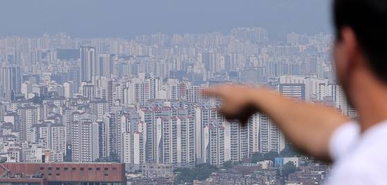 18일 서울 남산을 찾은 관광객이 도심 아파트 단지를 바라보고 있다. 뉴스1