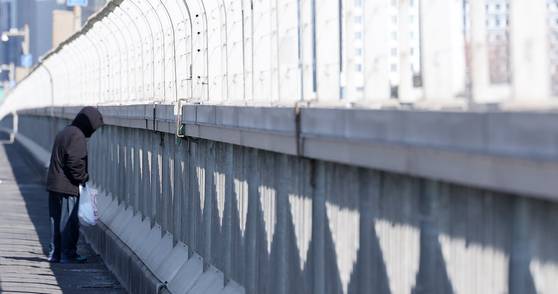 A passerby looks down at the Han River at the Mapo Bridge on Feb. 24, 2025. [NEWS1]