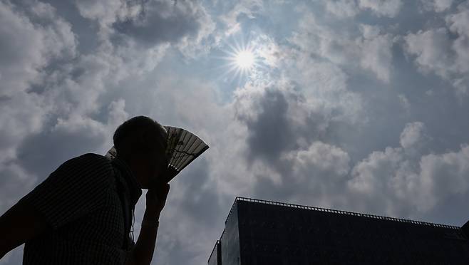 폭염이 이어지고 있는 지난 9일 서울 종로구 광화문광장에서 한 시민이 부채로 햇빛을 가리며 이동하고 있다. /사진=뉴스1