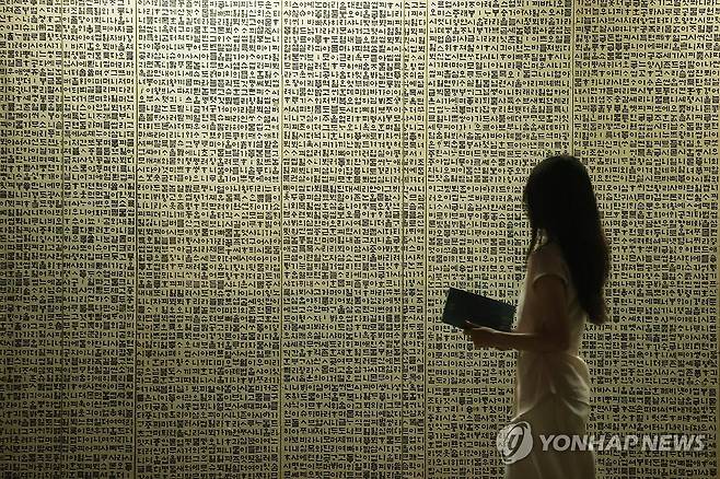 1만 자를 병풍에 담은 '월인천강지곡' (서울=연합뉴스) 강민지 기자 = 10일 서울 서초구 예술의전당 서울서예박물관에서 열린 '평보 서희환: 보통의 걸음' 전시 프리뷰에서 관계자가 '월인천강지곡'을 살펴보고 있다. 2025.7.10 mjkang@yna.co.kr