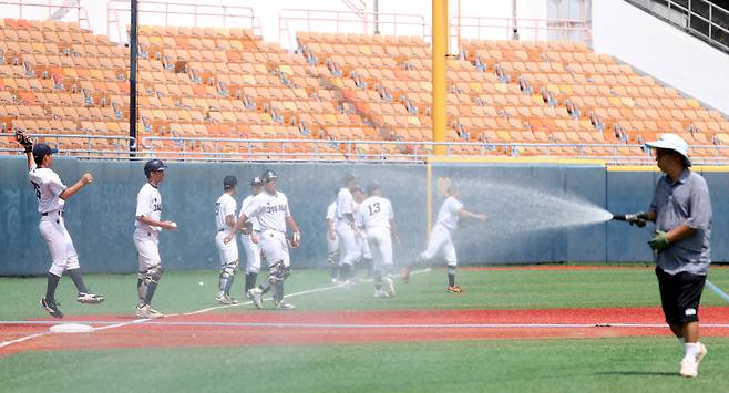 9일 서울 목동구장에서 열린 제80회 청룡기 고교야구선수권 대회 및 주말리그 왕중왕전 경기항공고와 경남고의 8강전. 3회가 끝난 후 관리요원이 경기장에 물을 뿌리고 있다. /정재근 스포츠조선 기자