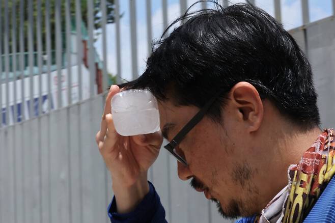 엿새째 폭염특보가 내려진 지난 2일 한 공사장 앞에서 건설노동자가 얼음물로 열기를 달래고 있다. 연합뉴스