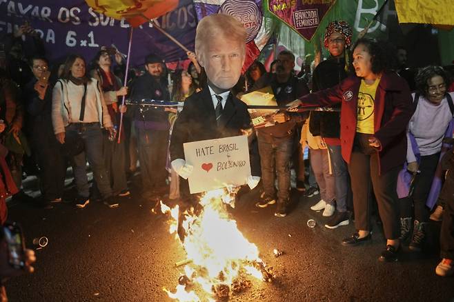 10일(현지시간) 브라질 상파울루에서 시위대가 도널드 트럼프 미국 대통령의 인형을 불태우고 있다. 시위대는 트럼프 대통령이 브라질산 제품에 대해 50% 관세를 결정한 것에 분노해 시위를 벌였다. /AP=뉴시스