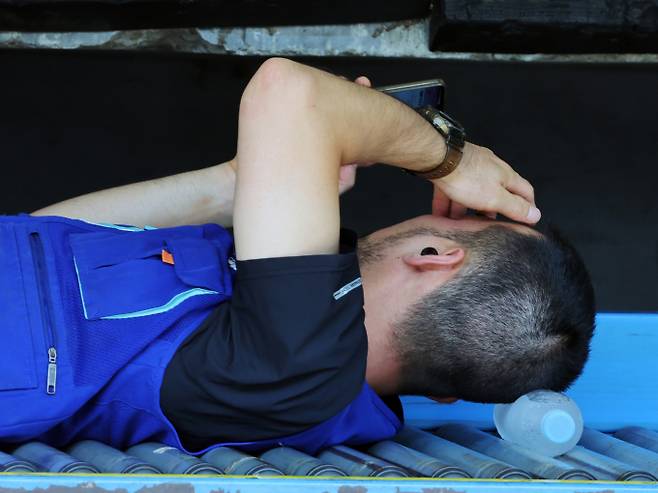 "아 만사기가 힘들어". 사진은 지난 9일 연일 폭염이 이어지고 있는 서울 시내 한 택배물류센터에서 노동자가 택배 분류 작업 중 휴식을 취하고 있는 모습. /사진=뉴스1