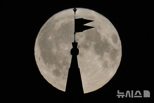 [모스크바=AP/뉴시스] 10일(현지 시간) 러시아 모스크바 크렘린의 트로이츠카야 탑 위 풍향계 뒤로 7월 보름달인 ‘벅 문'(Buck Moon)이 밝게 빛나고 있다. '벅 문'은 북미 원주민들의 명칭으로 수사슴(buck)의 뿔이 여름철 급속히 자라는 시기를 의미한다. 2025.07.11.