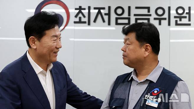 [세종=뉴시스] 강종민 기자 = 지난 10일 밤 세종시 정부세종청사에서 열린 최저임금위원회 전원회의에서 2026년도 적용 최저임금이 1만 320원으로 결정됐다. 회의가 끝난 후 류기정 사용자 위원과 류기섭 근로자 위원이 악수하고 있다. 이날 민주노총은 공익위원이 제시한 심의촉진구간에 반발, 집단 퇴장했다. 2024.07.10. ppkjm@newsis.com