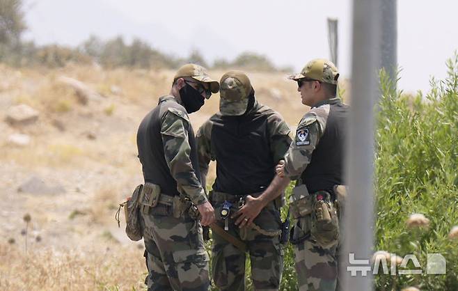 [술레이마니아(이라크)=AP/뉴시스]쿠르드노동자당(PKK) 전투원들이 대부분 숨어 있던 이라크 쿠르드자치지구 술레이마니아 인근 산에서 11일 자치지역 정부군들이 PKK 전투원들의 무장해제 기념식을 앞두고 경계를 서고 있다. 약 30명의 쿠르드노동자당(PKK) 전사들이 4만명 이상의 목숨을 앗아간 장기 분쟁 종식을 위해 11일 이라크 쿠르디스탄에서 열린 기념식에서 무기를 폐기했다고 프랑스24가 보도했다. 2025.07.11.