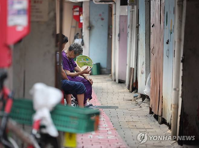 쪽방촌과 부채질 (서울=연합뉴스) 서명곤 기자 = 기록적인 폭염이 계속된 9일 서울 영등포 쪽방촌 골목에서 한 주민이 부채질을 하고 있다. 2025.7.9 seephoto@yna.co.kr