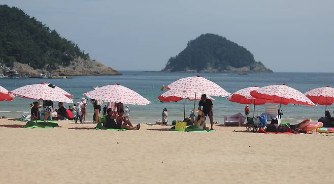 폭염이 이어진 12일 오후 경남 남해군 상주면 상주은모래비치에서 피서객이 파라솔 아래에서 쉬고 있다. 연합뉴스