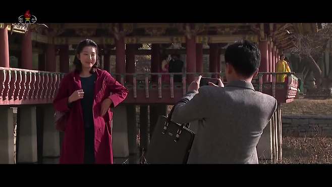 드라마 속에서 남녀 주인공이 데이트를 하면서 스마트폰으로 사진을 찍어주는 모습 [조선중앙TV 캡처]