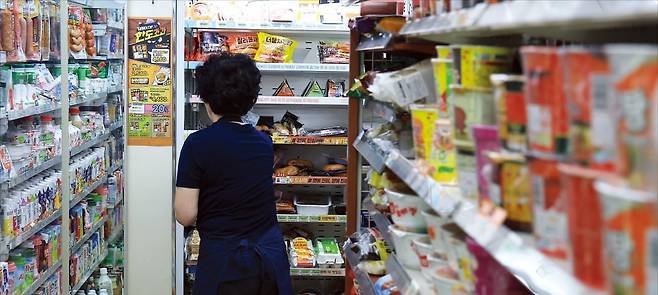 < 인건비 부담스러운 자영업자 > 최저임금위원회가 지난 10일 내년 최저임금을 올해보다 2.9% 오른 시간당 1만320원으로 결정했다. 11일 서울시내 한 편의점에서 직원이 물건을 정리하고 있다. 편의점업은 채용공고의 약 80%가 최저시급인 업종이다.  /뉴스1