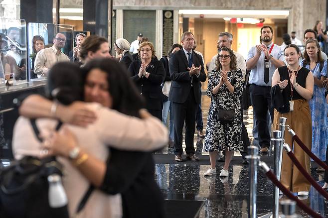 국무부 소속 공무원과 외교관에 대한 해고 통보가 이뤄진 지난 11일(현지시간) 국무부 직원들이 국무부 본부가 있는 워싱턴 해리 S. 트루먼 빌딩 로비에서 국무부를 떠나는 동료에게 격려와 위로의 박수를 보내고 있다. AP연합뉴스