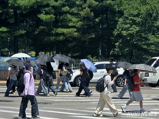 9일 오후 12시 경기 수원시 영통구 한 사거리에서 시민들이 뜨거운 햇볕을 피하기 위해 양산을 쓴 채 걸어가고 있다. 노유지 기자&nbsp;