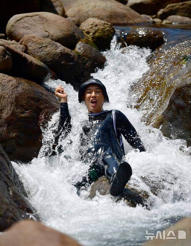 [구례=뉴시스] 이현행 기자 =12일 오전 전남 구례 지리산 피아골 계곡에서 피서객이 작은 폭포를 내려오고 있다. 2025.07.12. lhh@newsis.com