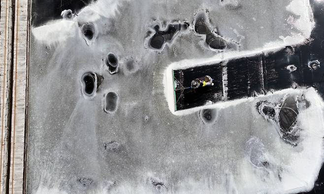 염부 전동길씨가 전라남도 신안 도초도 염전에서 커다란 밀대를 들고, 반짝이는 결정지 위를 천천히 걸으며 소금을 긁어모으고 있다. 염전에서 채염 시간은 오후 3~4시쯤에 수확하는 것이 일반적이다. 이 시간대는 소금 결정이 충분히 굳고 수분이 가장 적은 상태여서 수확하기에 가장 적절하다.