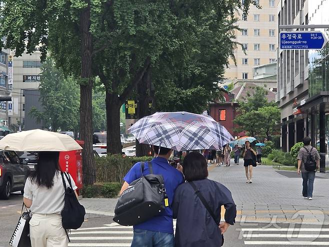 13일 서울 종로구 종각역 인근에 비가 내리며 무더위를 식히고 있다. 시민들이 우산을 쓰고 길을 거닐고 있다. 2025.7.13/뉴스1 ⓒ News1 황덕현 기후환경전문기자