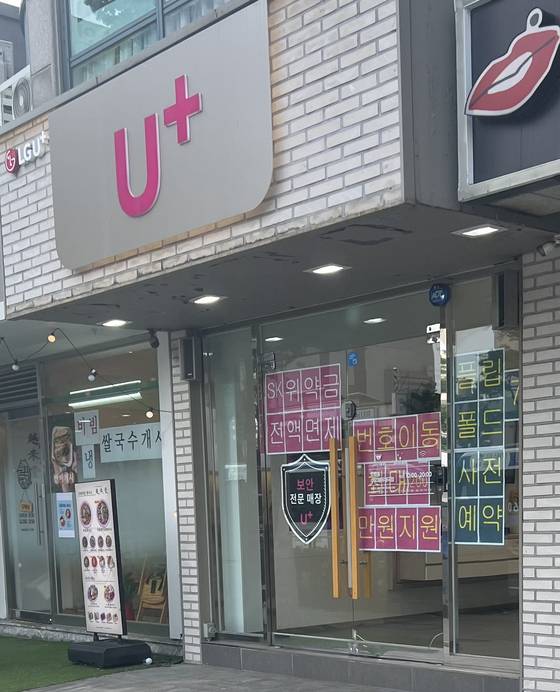 A telecommunciations store in central Seoul with a sign on its entrance that reads “Up to 2 million won [$1,450] support for number transfer″ is seen on July 10. [JOONGANG ILBO]