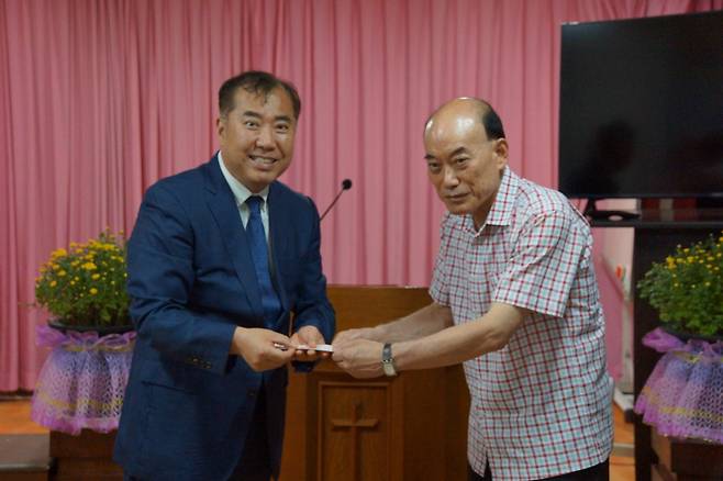 김형섭(왼쪽) 부산해운대기독교총연합회장이 지난달 26일 누전으로 본당이 전소 된 부산 신성교회를 찾아 김홍종(오른쪽) 목사에게 위로금을 전달하고 있다.