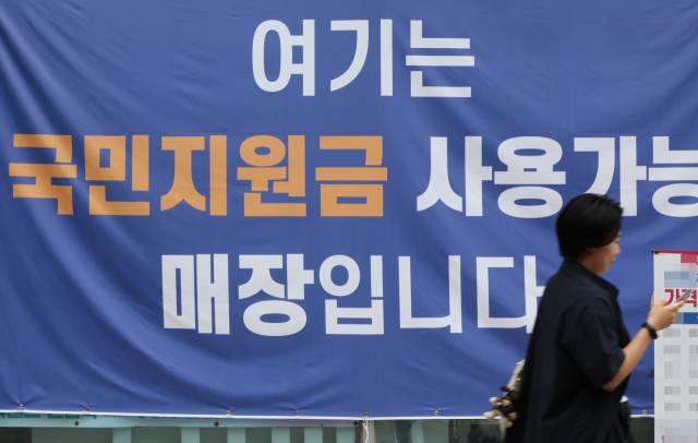 오는 21일 정부의 '민생회복 소비쿠폰' 지급을 앞두고 전통시장과 동네마트, 편의점업계에서 경기 회복 기대감이 확산하고 있다. 정부는 소비 진작을 통한 내수 회복을 목표로 이번 소비쿠폰을 두 차례에 걸쳐 최대 55만원 지급할 예정이다. 사진은 13일 서울 한 상점에 붙은 민생회복 소비쿠폰 사용처 안내문 모습. /연합뉴스