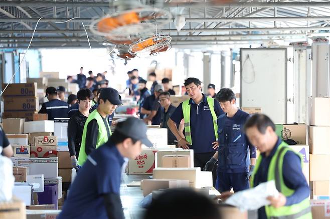 폭염 속 택배 물건과 사투 (광주=연합뉴스) 천정인 기자 = 폭염특보가 이어진 지난 11일 오전 광주 광산구 한 택배회사 물류창고에서 노동자들이 선풍기 아래서 택배 물건을 분류하고 있다. 2025.7.13 iny@yna.co.kr